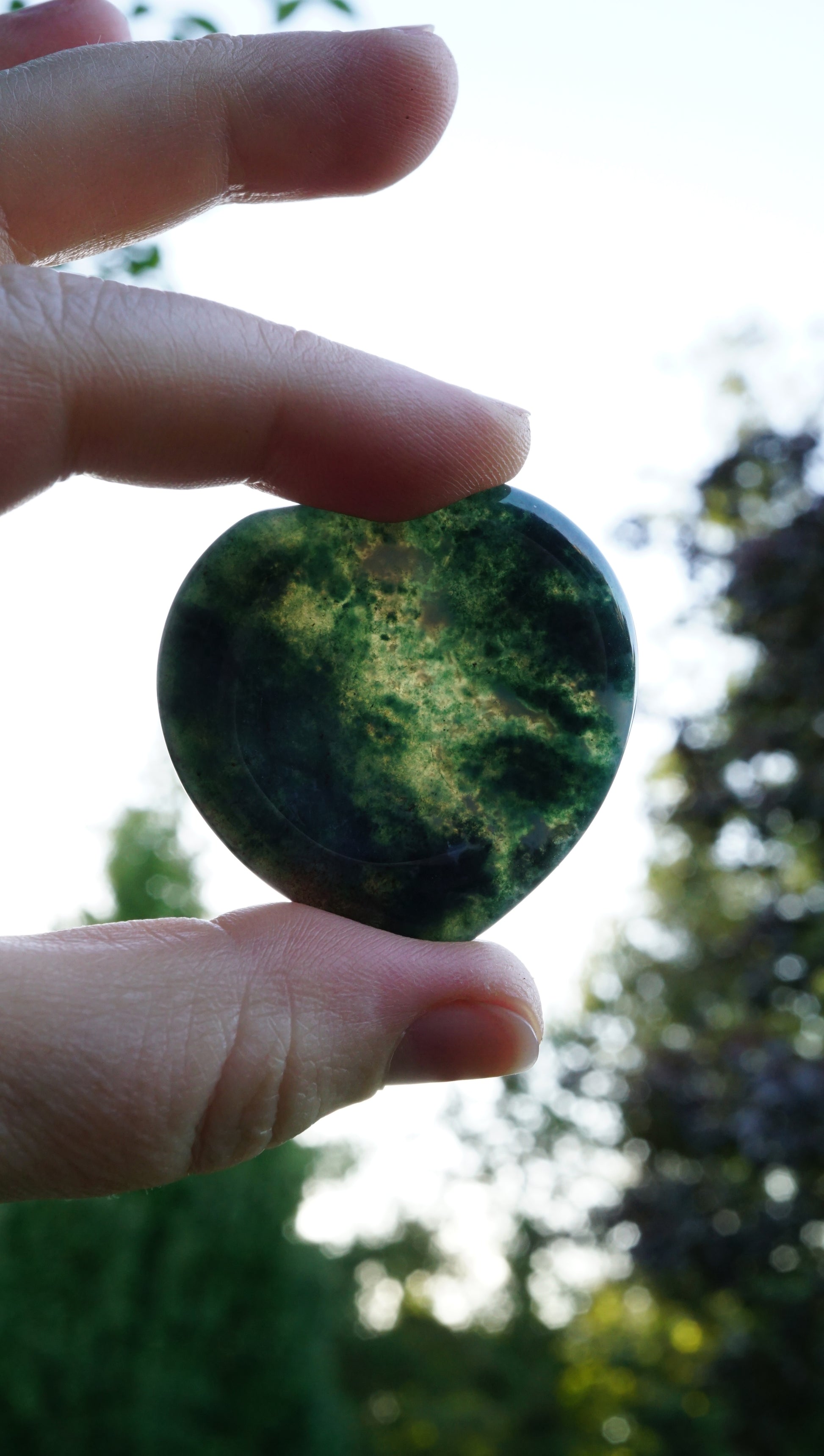 green moss agate heart stone showing off in the sunlight