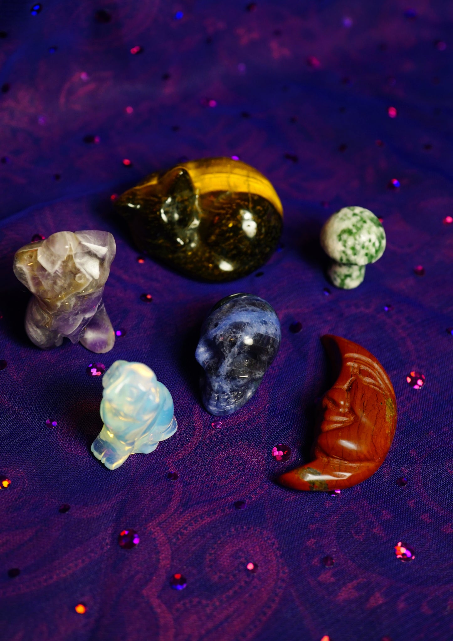 Collection of various crystals on a purple textured surface