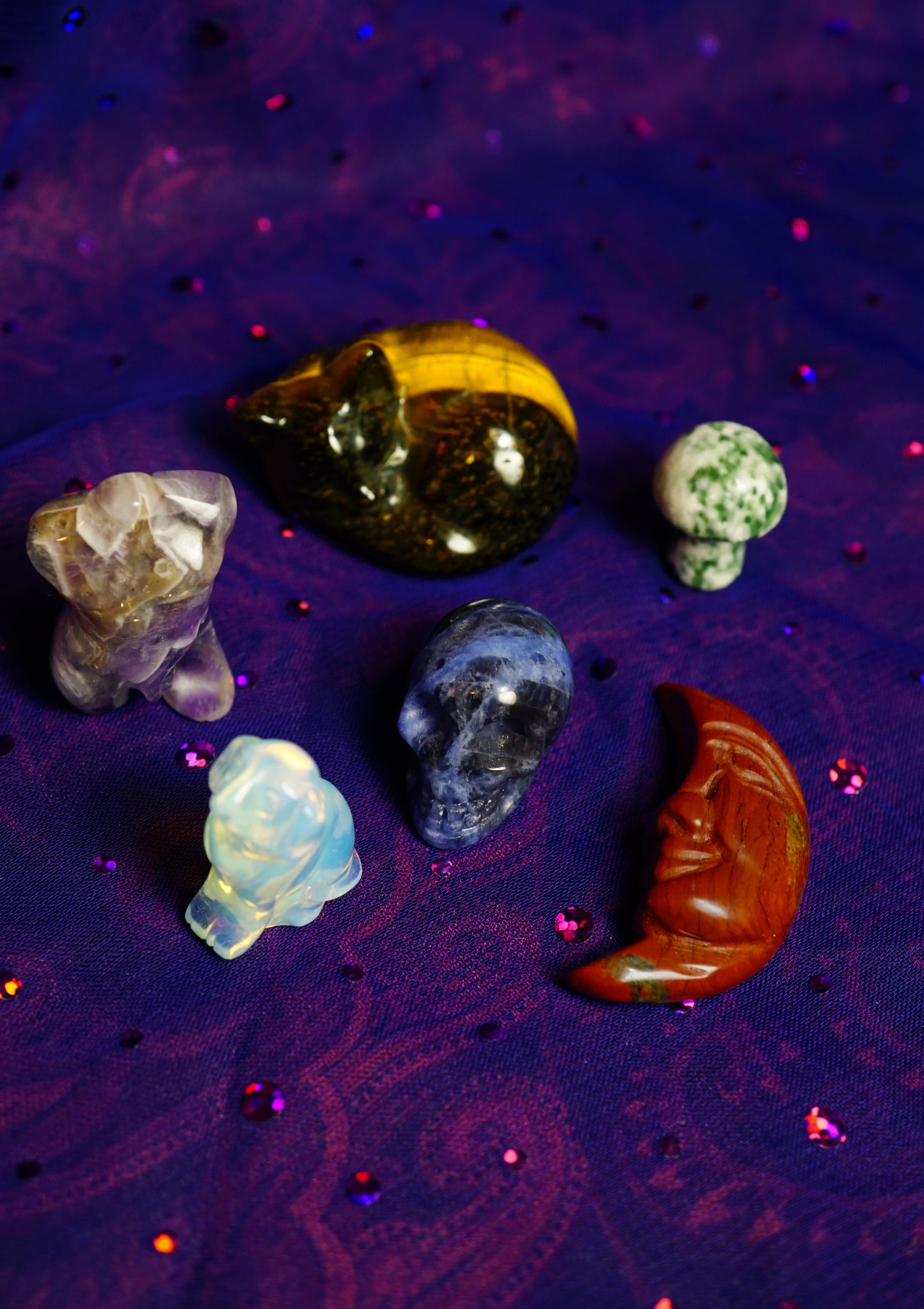 Collection of various crystals on a purple textured surface