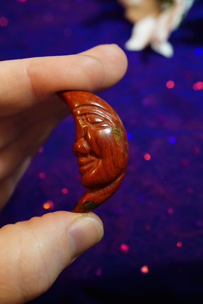 carved red jasper moon face in hands