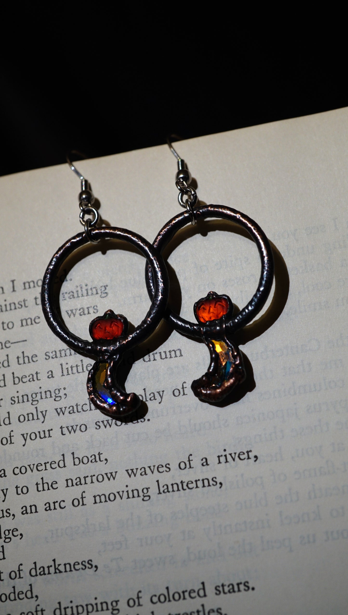 Pair of earrings with circular design on a book page