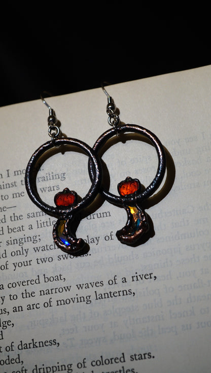 Pair of earrings with circular design on a book page