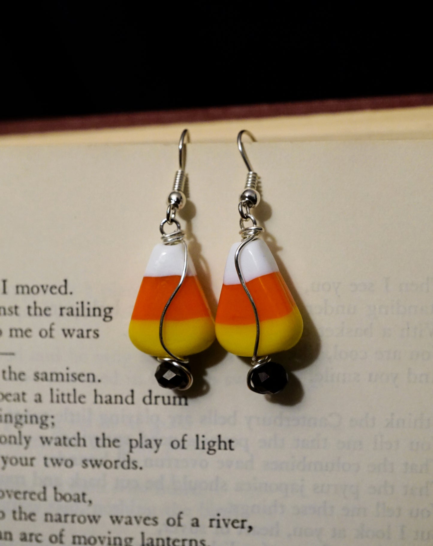 Candy corn-themed earrings on a book page