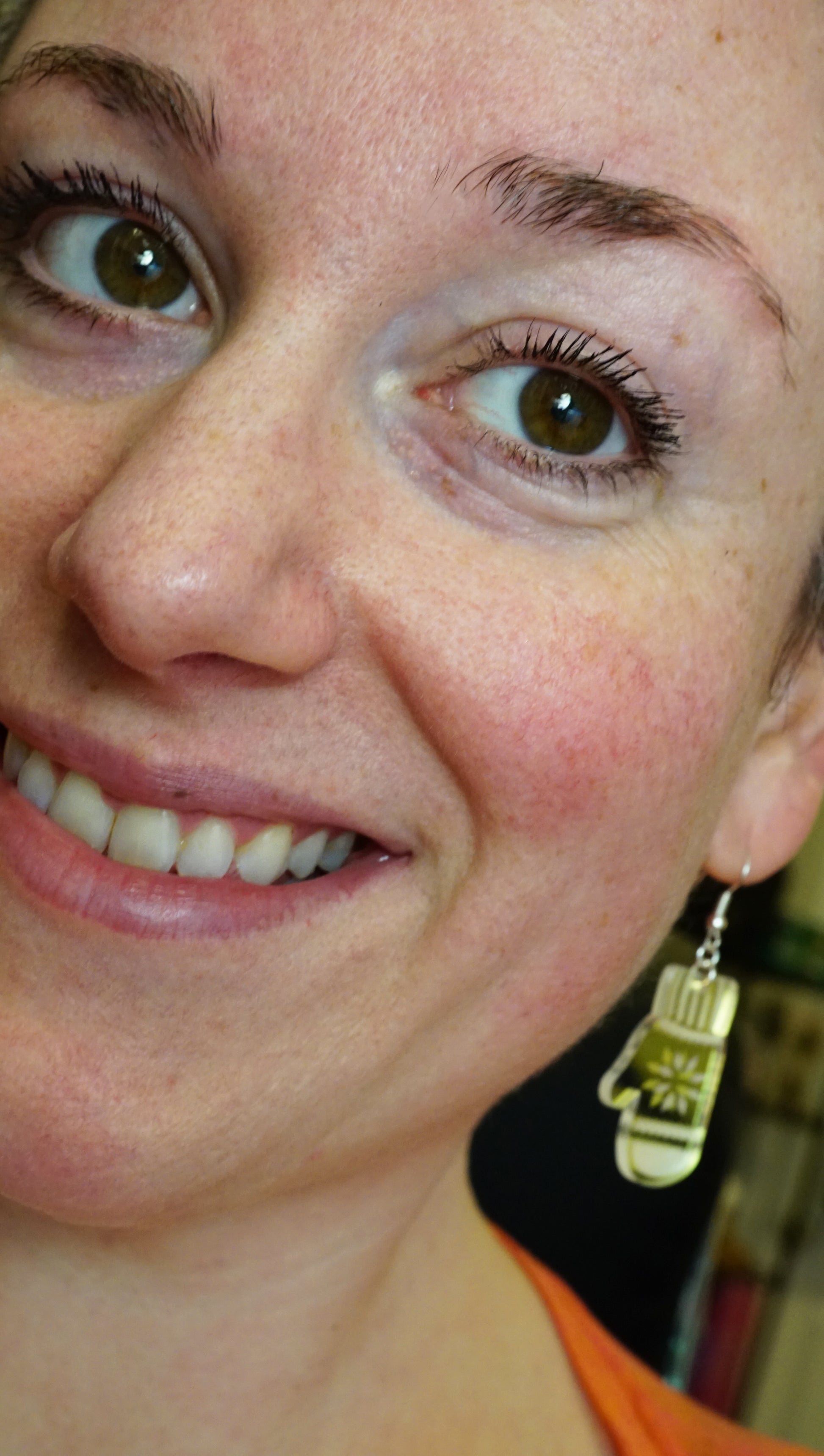 close up of woman wearing mitten earrings