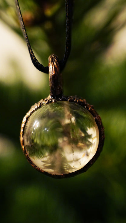 clear quartz ornament against a green christmas tree