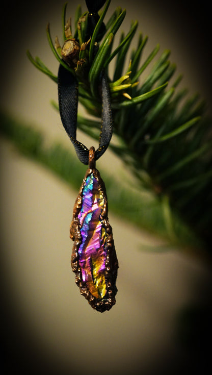 multicolored ornament hanging from black ribbon on green christmas tree in house