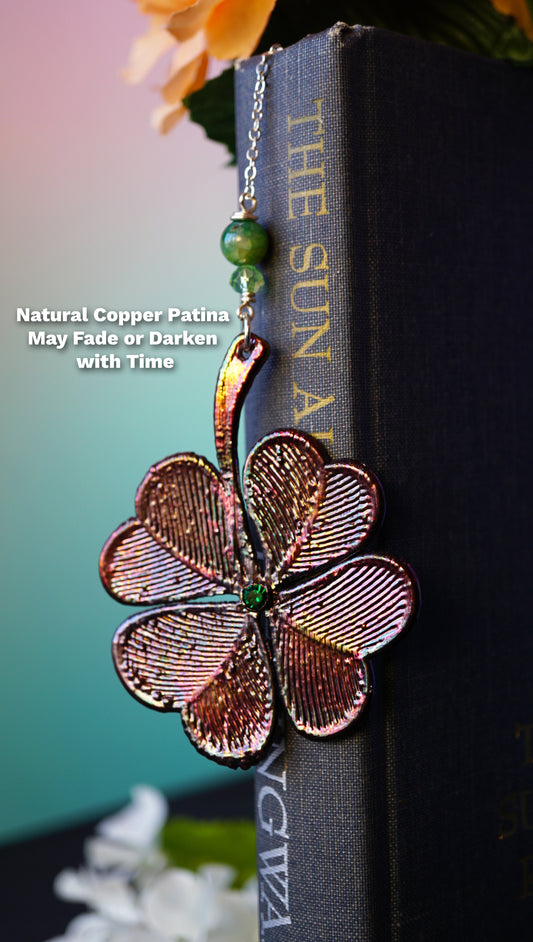 copper shamrock bookmark, says "natural copper patina may fade or darken with time" with pink and blue gradient background