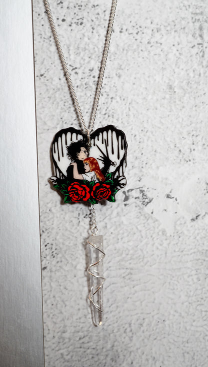 Necklace with a heart-shaped pendant featuring a edward scissor hands and kim. Red roses on  textured white heart with black drops. snowy white background