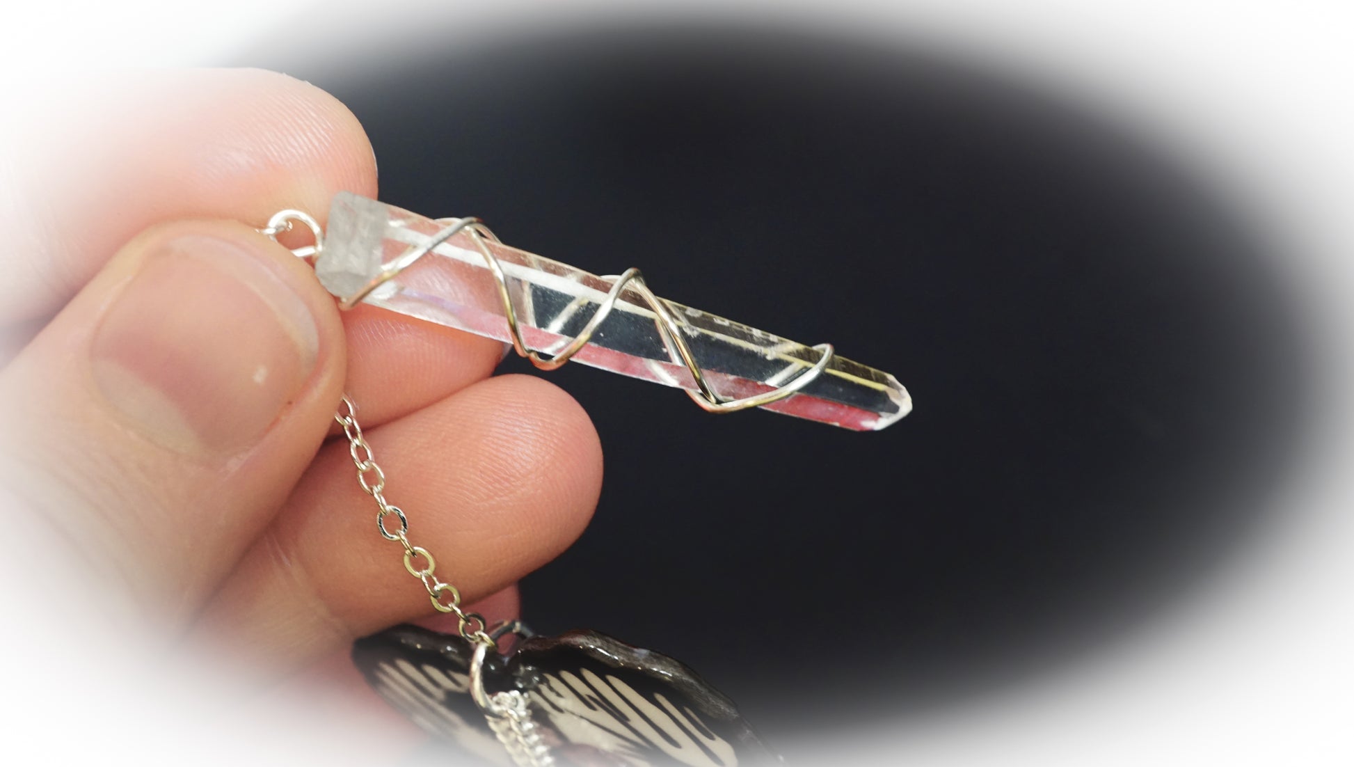 wire wrapped clear quartz in hand
