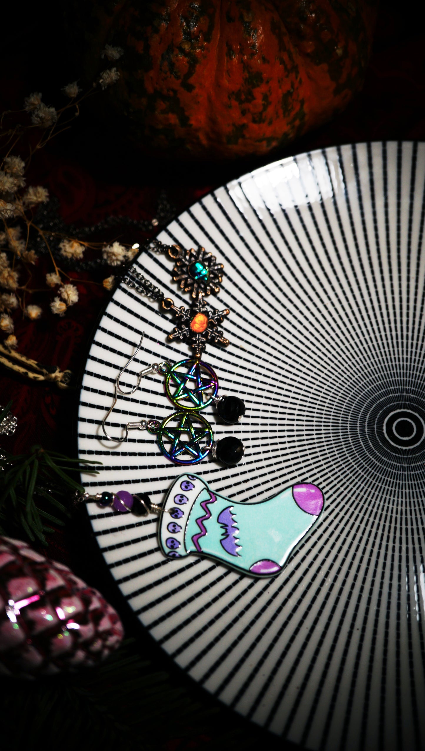 spooky Christmas jewelry displayed together on a black and white beetlejuice-like plate