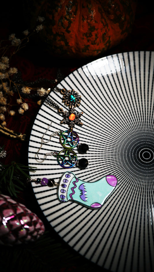 spooky Christmas jewelry displayed together on a black and white beetlejuice-like plate